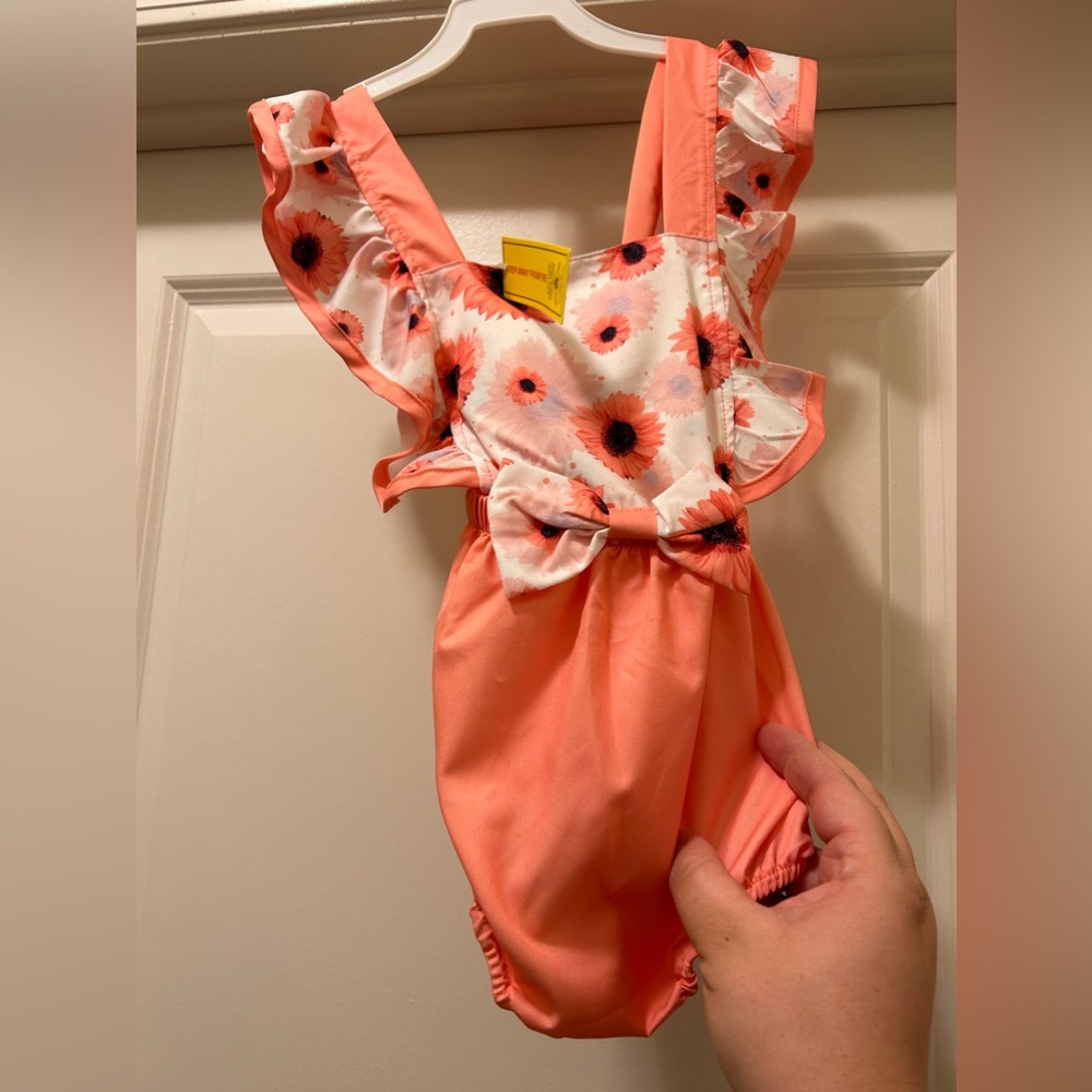 NWT floral romper 
Peach color w/criss cross back 
18-24M